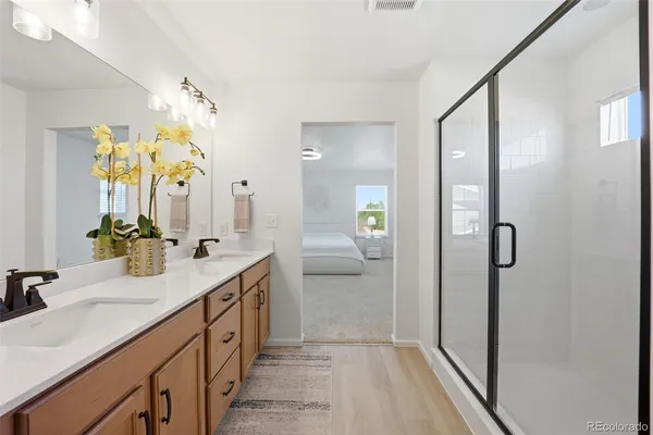 a en suite bathroom with a granite countertop sink mirror and shower