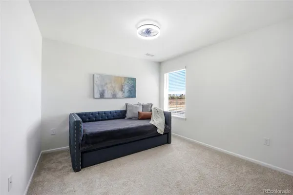 a bedroom with a bed and a lamp on the dresser