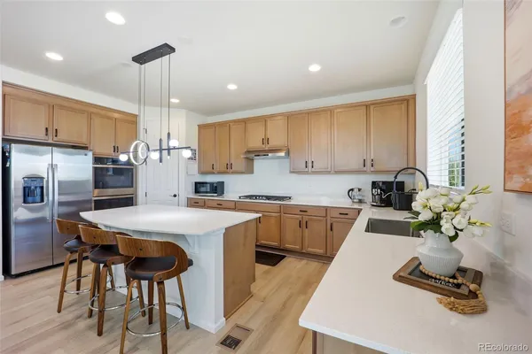 a kitchen with a sink a counter top appliances and cabinets