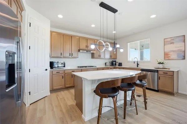 a kitchen with kitchen island granite countertop wooden floors and white cabinets