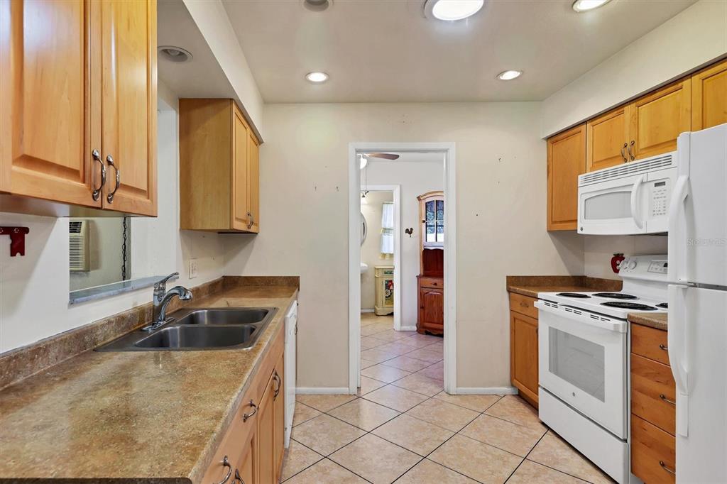 3621 Glen Ridge Lane Sarasota, FL 34233 - Photo 16 of 36 a kitchen with granite countertop a sink a stove and cabinets