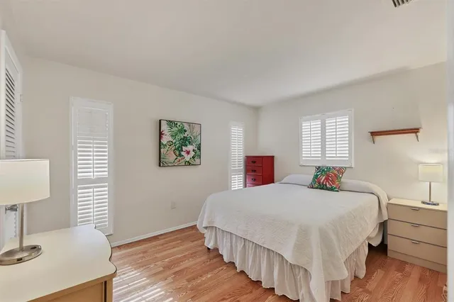 a bedroom with a bed and a wooden floor