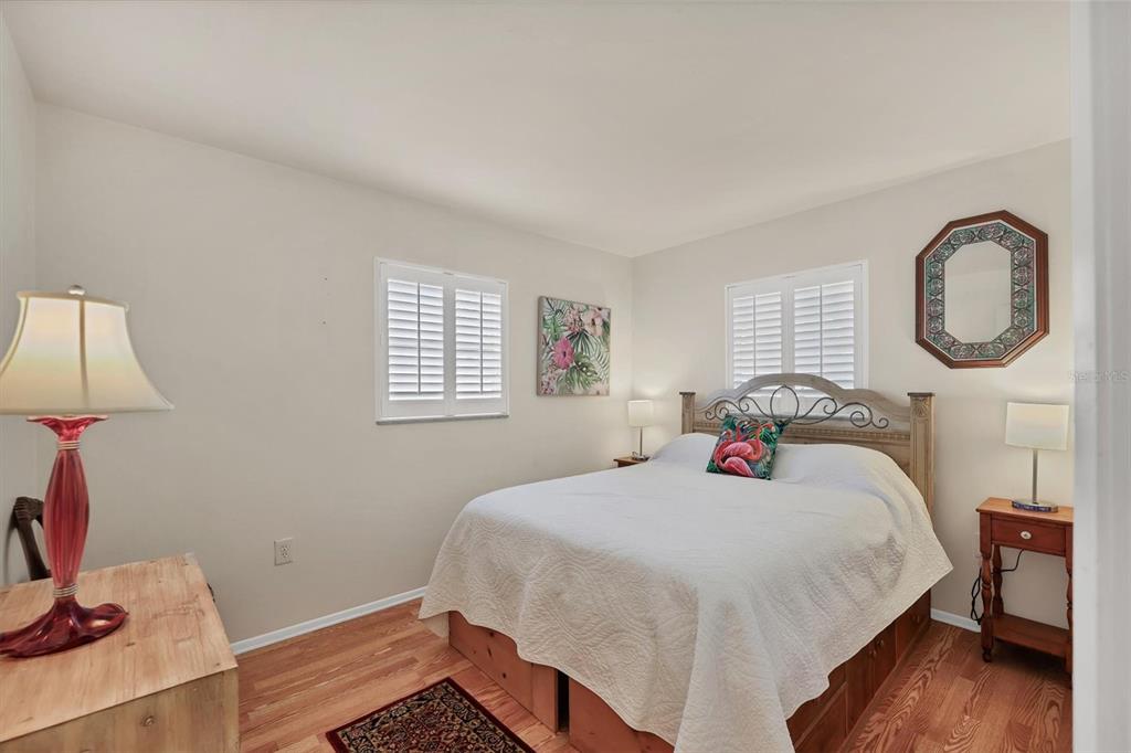 3621 Glen Ridge Lane Sarasota, FL 34233 - Photo 22 of 36 a bedroom with a bed and a wooden floor