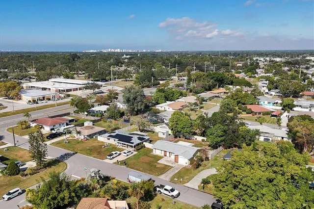 an aerial view of residential houses with outdoor space and trees