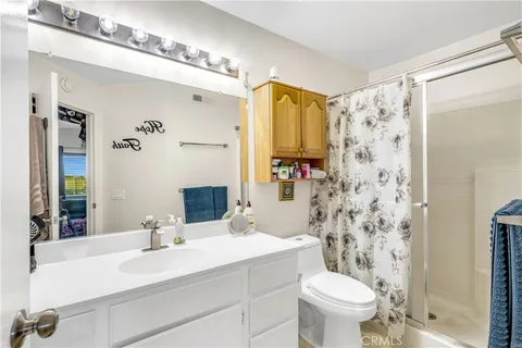 a bathroom with a sink toilet a mirror a vanity and shower