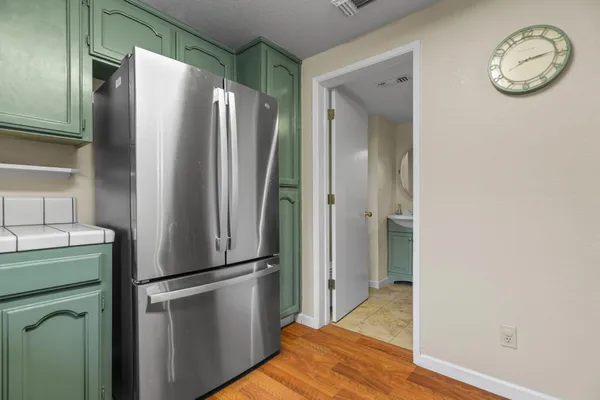 a view of a kitchen with refrigerator and cabinets
