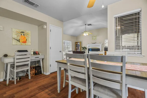 a view of a kitchen with kitchen island stainless steel appliances wooden floor dining table and chairs