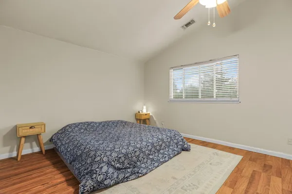 a bedroom with a bed and wooden floor