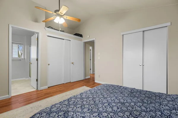 a bedroom with a bed and a chandelier fan