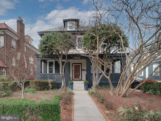 a front view of a house with a yard and potted plants