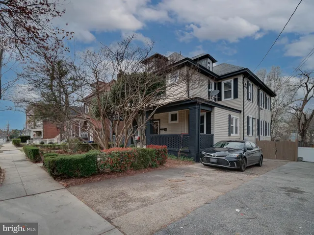 a front view of a house with a yard and potted plants