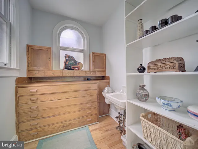 a spacious bedroom with a bed a dresser and a large window