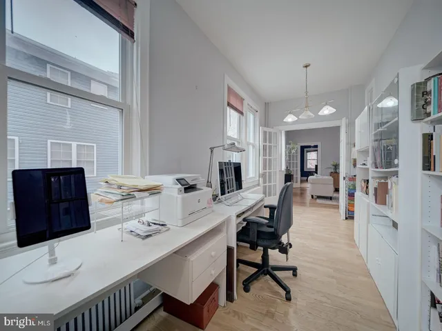 a bathroom with a toilet a sink a mirror a window and vanity