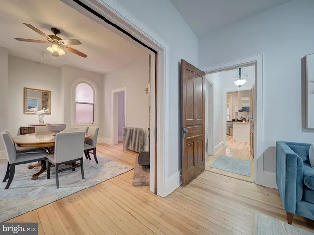 a view of an empty room with wooden floor and stairs