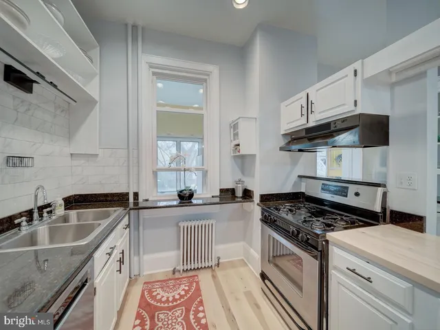 a bedroom with a bed and a lamp on dresser