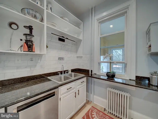 a bedroom with a bed and a potted plant on dresser