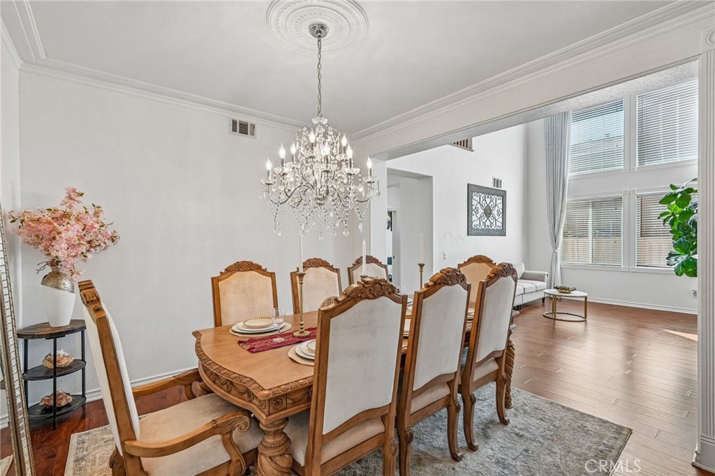 46101 Sharon Street Temecula, CA 92592 - Photo 11 of 34 a dining room with furniture a chandelier and wooden floor