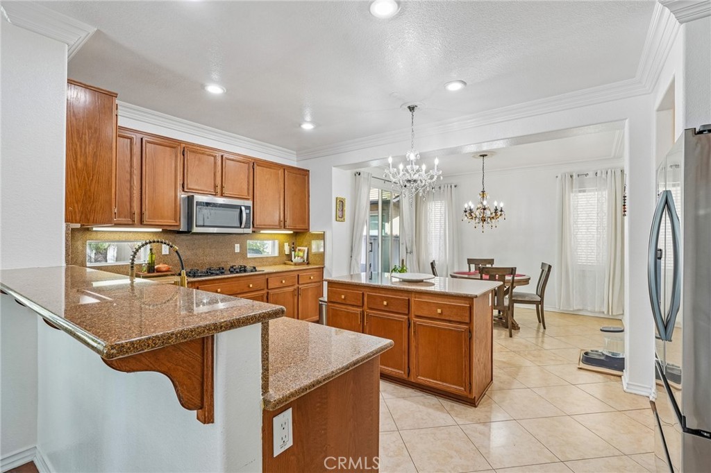 46101 Sharon Street Temecula, CA 92592 - Photo 13 of 34 a kitchen with stainless steel appliances granite countertop a sink stove and refrigerator