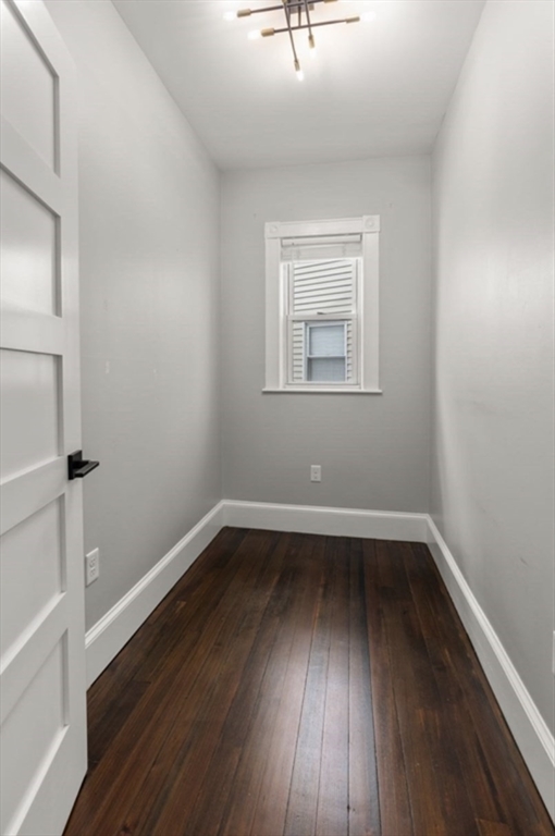 101 Draper Street, Unit 2 Boston, MA 02122 - Photo 13 of 19 an empty room with wooden floor and windows