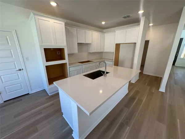 a kitchen with a refrigerator a stove and wooden floor
