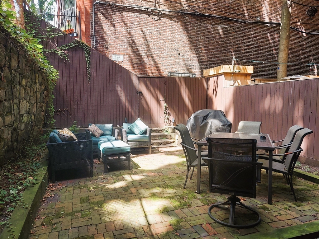 63 Chandler Street, Unit A Boston, MA 02116 - Photo 8 of 9 a view of backyard with table and chairs potted plants and a large tree
