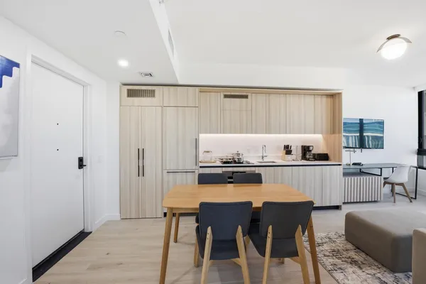a kitchen with a table chairs refrigerator and cabinets