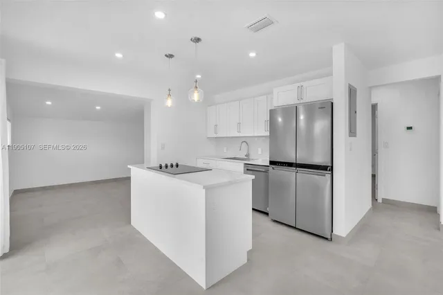 a kitchen with refrigerator and white cabinets