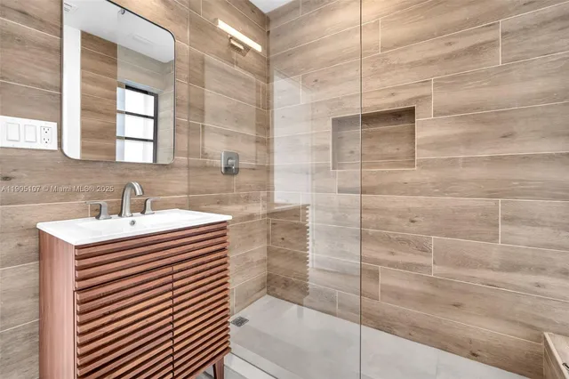 a bathroom with a sink shower and a mirror