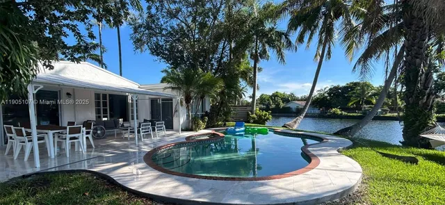 a view of a house with swimming pool and sitting area