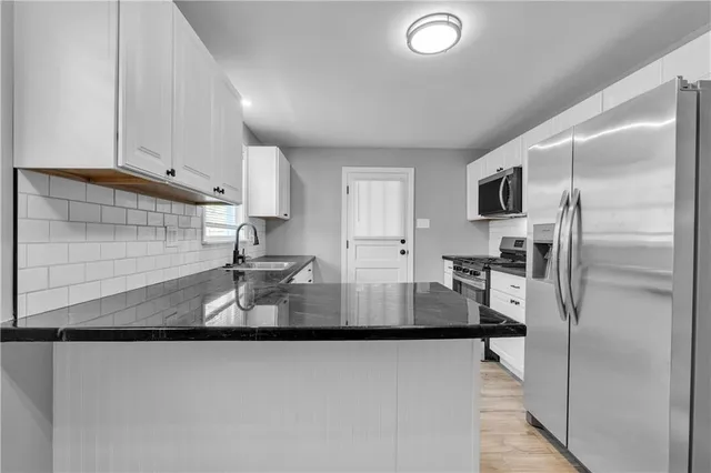 a kitchen with kitchen island a counter top space cabinets stainless steel appliances and a sink