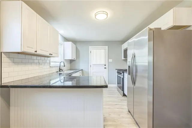 a kitchen with stainless steel appliances granite countertop a refrigerator a sink and a stove