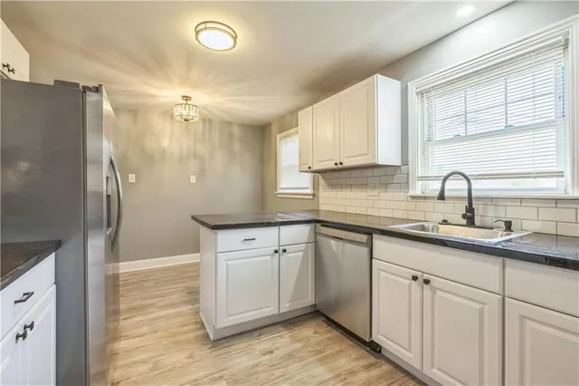 a kitchen with stainless steel appliances granite countertop a sink and a refrigerator