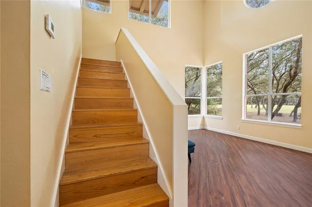 a view of a hallway with wooden floor and staircase