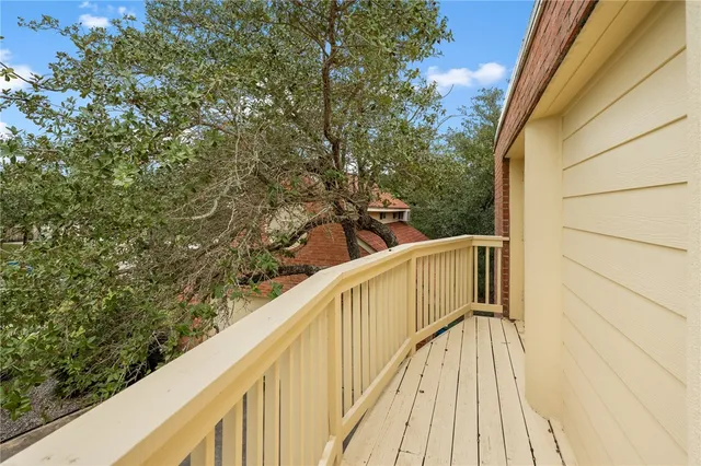 a view of balcony with wooden floor and fence