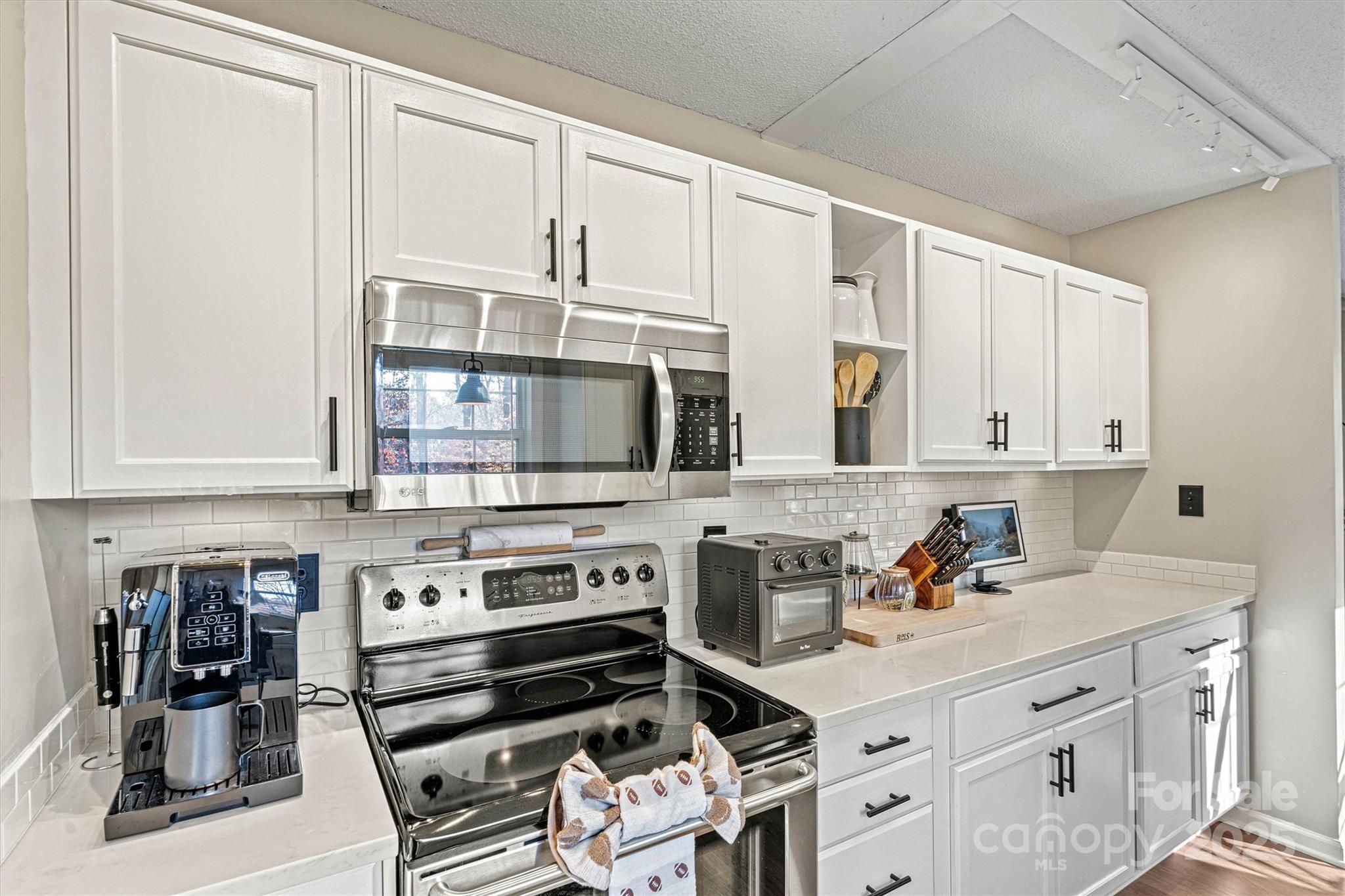 7176 Hunters Bluff Drive Denver, NC 28037 - Photo 9 of 36 a kitchen with stainless steel appliances a stove a sink and cabinets