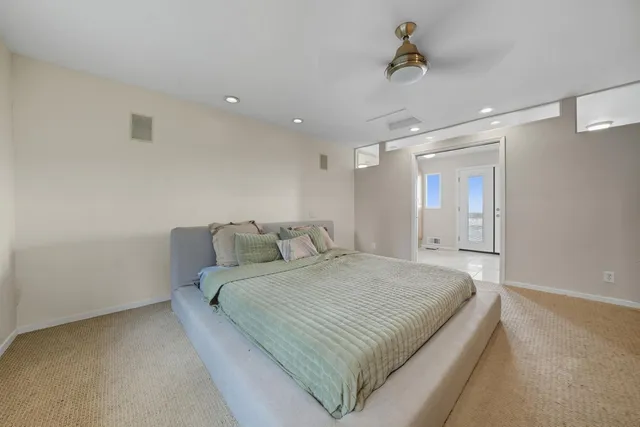 a view of house with roof deck and couches with wooden floor and fence