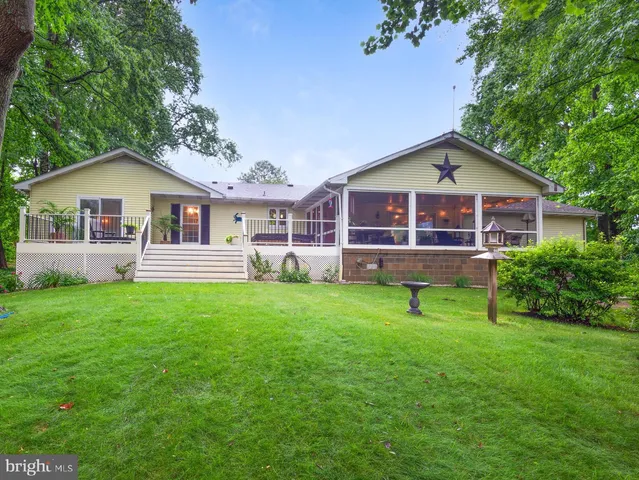a view of backyard with deck and outdoor seating
