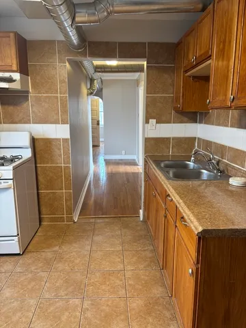 a kitchen with kitchen island granite countertop a sink and a stove