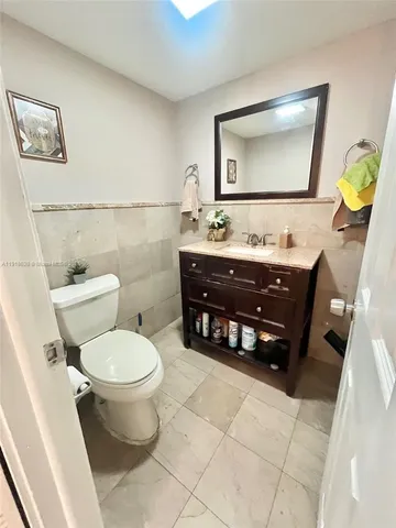 a bathroom with a toilet a sink and mirror