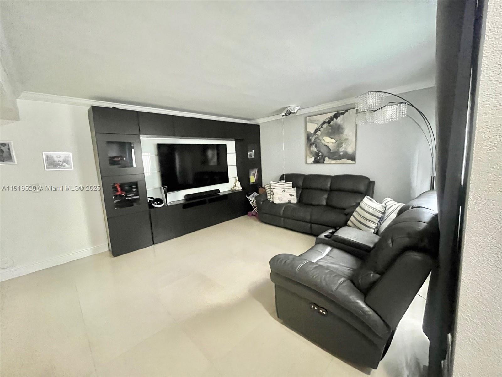 1990 Southwest 121st Court, Unit 232 Miami, FL 33175 - Photo 4 of 28 a living room with furniture and a flat screen tv