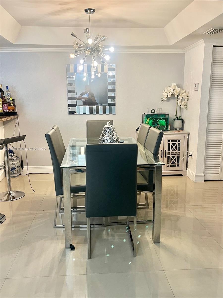 1990 Southwest 121st Court, Unit 232 Miami, FL 33175 - Photo 6 of 28 a view of a dining room with furniture and chandelier