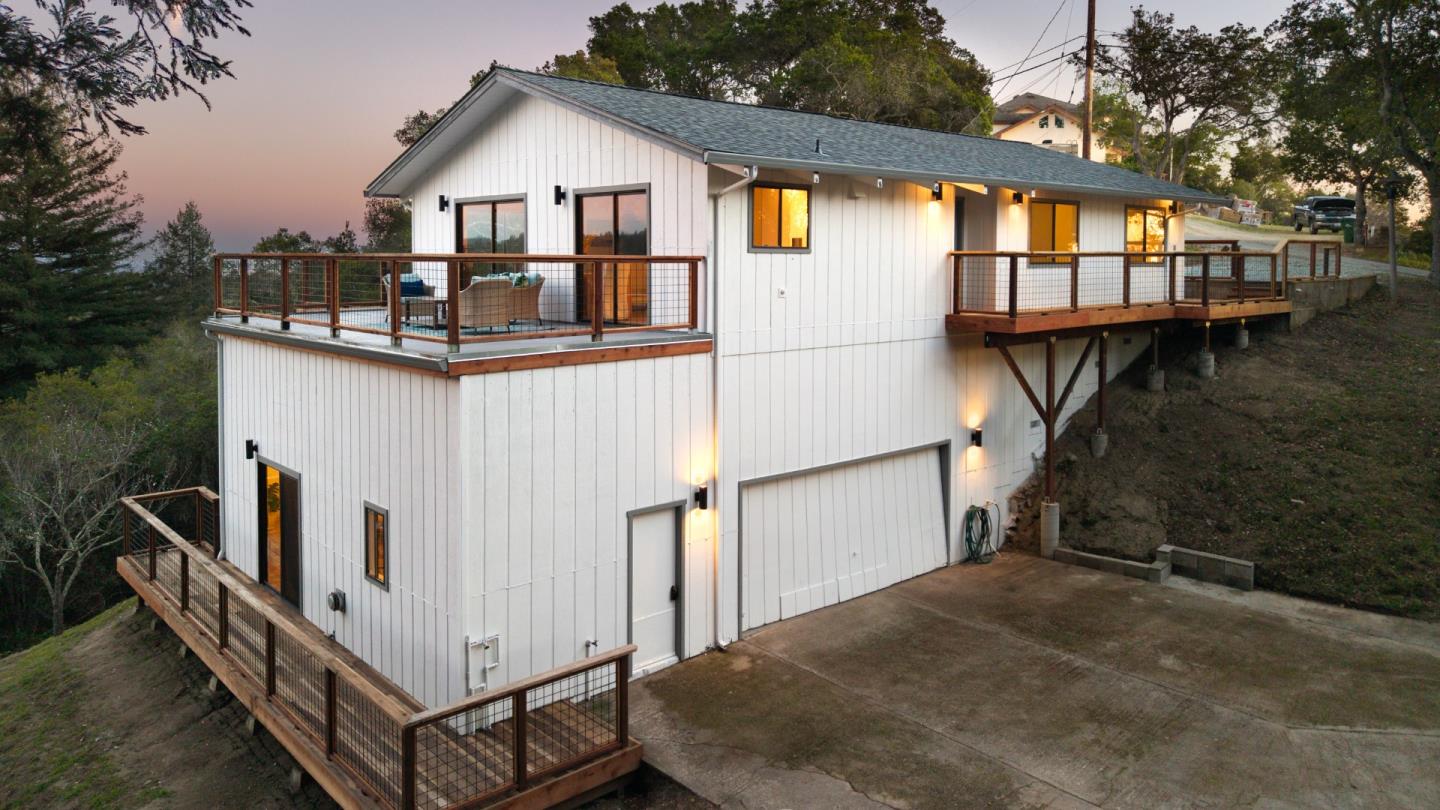 1130 Hidden Valley Road Soquel, CA 95073 - Photo 41 of 44 a view of a white house with large windows and a small yard