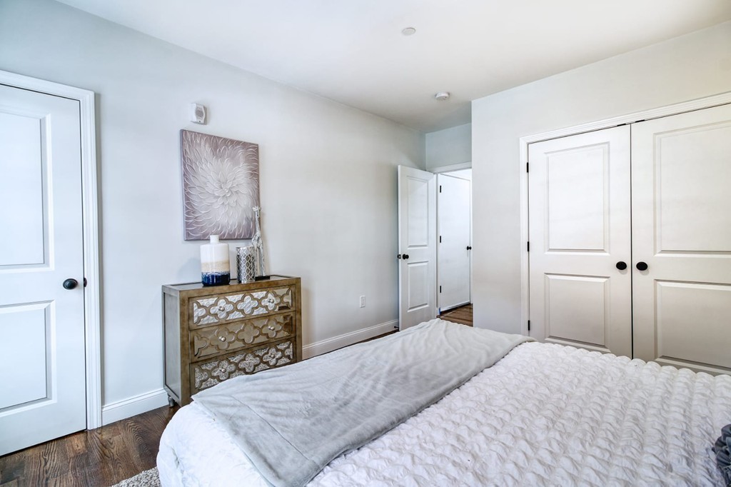 51 Havre Street, Unit 1 Boston, MA 02128 - Photo 6 of 10 a bedroom with a bed and a lamp