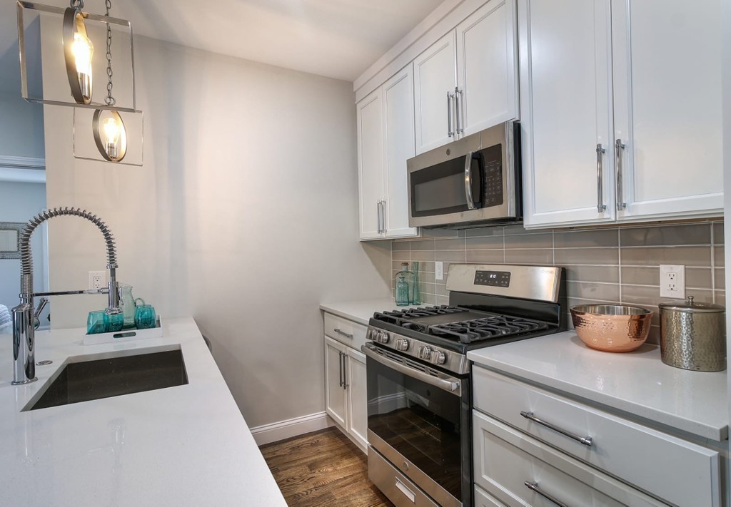 51 Havre Street, Unit 1 Boston, MA 02128 - Photo 7 of 10 a kitchen with granite countertop cabinets stainless steel appliances and a wooden floor
