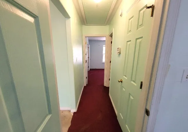 a view of a hallway with wooden floor and a glass door