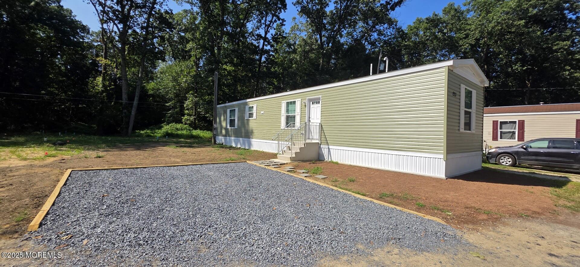a backyard of a house with barbeque oven and trees