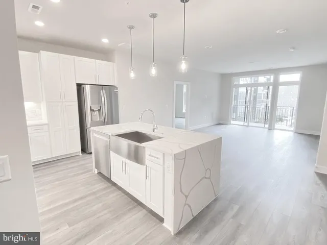 a kitchen with kitchen island a sink appliances and a large window