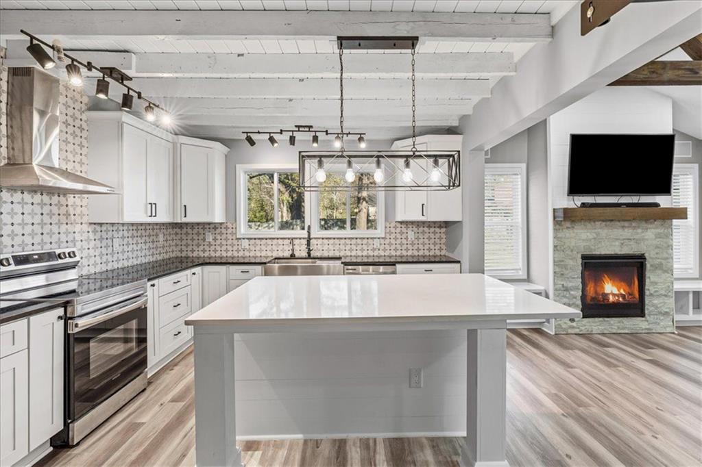 18 Farmer Road Northwest Cartersville, GA 30120 - Photo 11 of 33 a large kitchen with a large counter top a stove and a chandelier