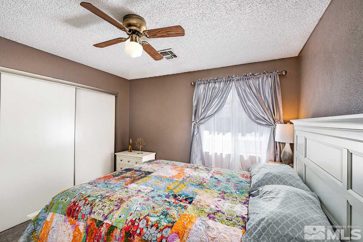 4544 Matich Drive Reno, NV 89502 - Photo 10 of 19 a bedroom with a bed and a chandelier