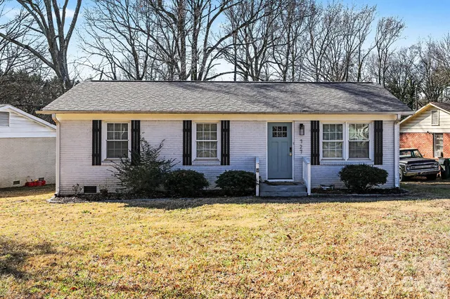 a view of house with yard and outdoor seating